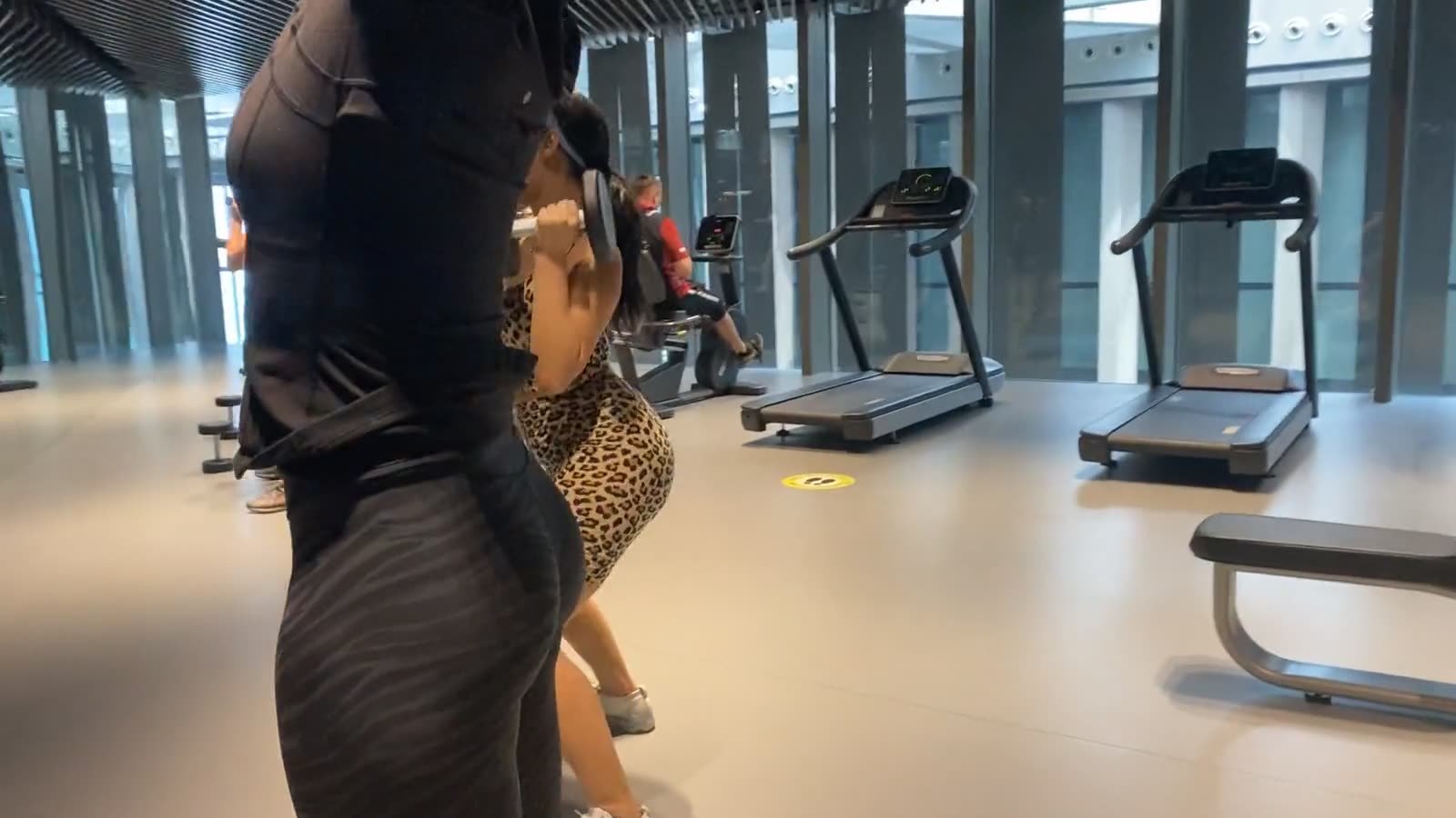 Max coaching a client through a dumbbell exercise in a Dubai gym